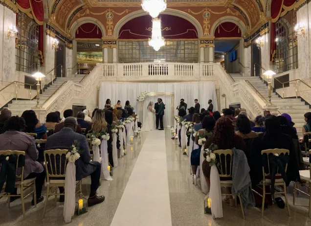 wedding ceremony taking place between two marble staircases