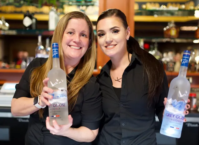 2 bartenders holding grey goose