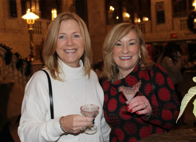 Two women standing with festive martini glasses